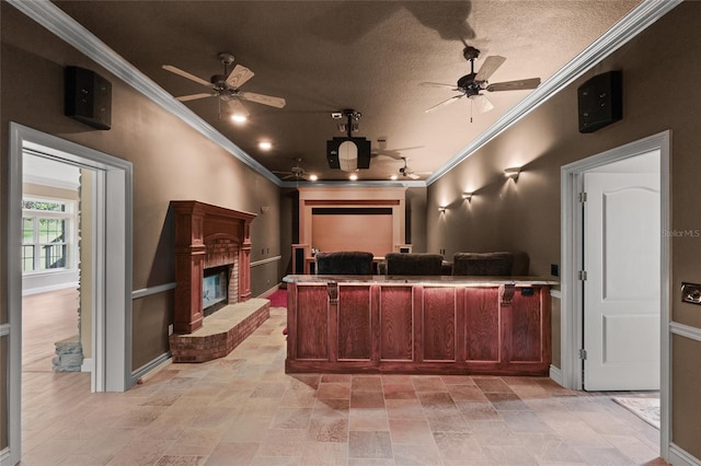 home theater featuring a brick fireplace, ornamental molding, and ceiling fan