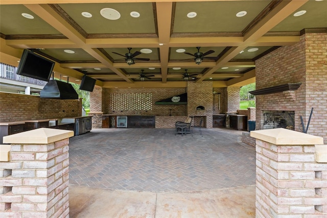 view of patio with an outdoor brick fireplace, an outdoor kitchen, and ceiling fan