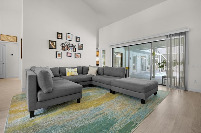 living room with hardwood / wood-style flooring, high vaulted ceiling, and a healthy amount of sunlight