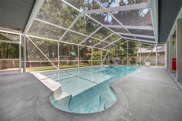 view of swimming pool featuring a lanai, a patio area, and a playground