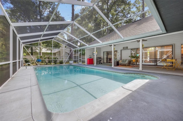 view of pool featuring glass enclosure, area for grilling, and a patio