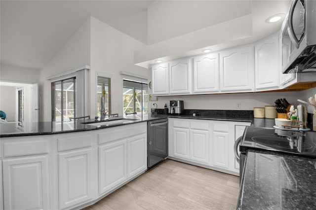 kitchen with light hardwood / wood-style flooring, white cabinets, dark stone counters, and black dishwasher