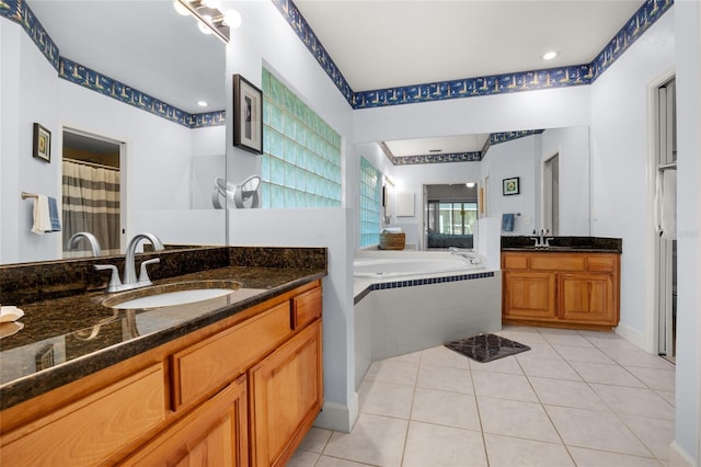 bathroom featuring vanity, tile patterned floors, and tiled tub