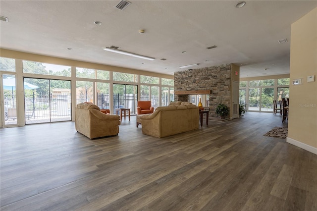 unfurnished living room featuring dark wood-type flooring, a wealth of natural light, and a fireplace