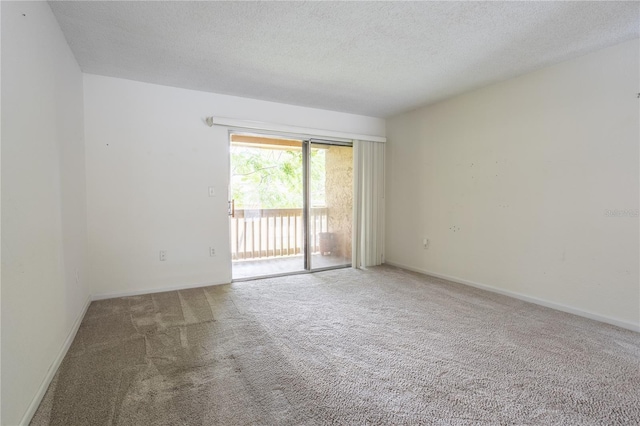 empty room with a textured ceiling and carpet floors