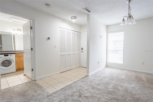 carpeted foyer with a textured ceiling and washer / dryer