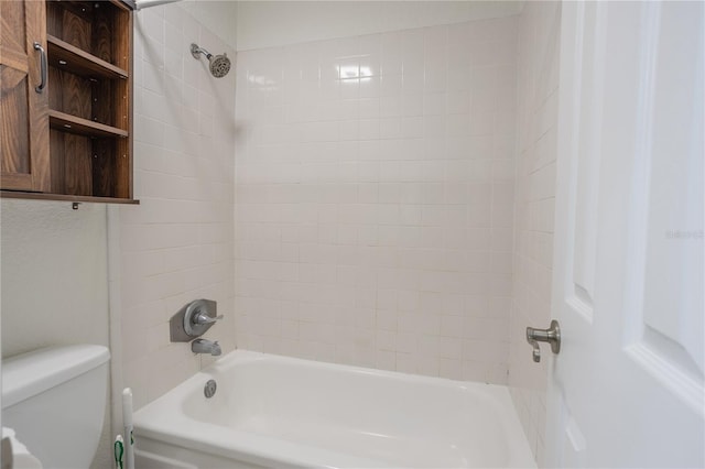 bathroom with toilet and tiled shower / bath combo