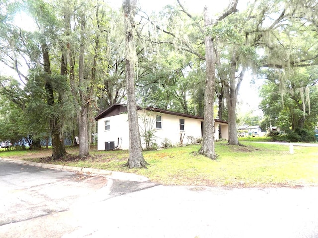 view of home's exterior with central AC and a lawn