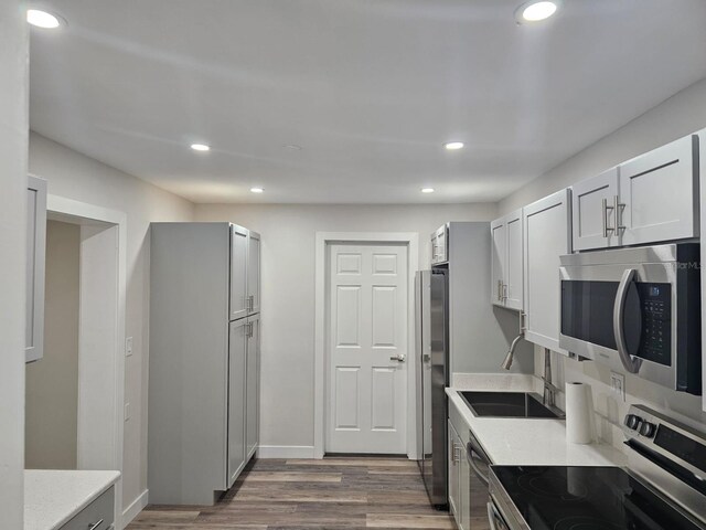 kitchen with sink, stainless steel appliances, and dark hardwood / wood-style floors