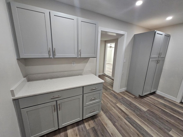 kitchen featuring recessed lighting, baseboards, gray cabinets, and dark wood-style flooring