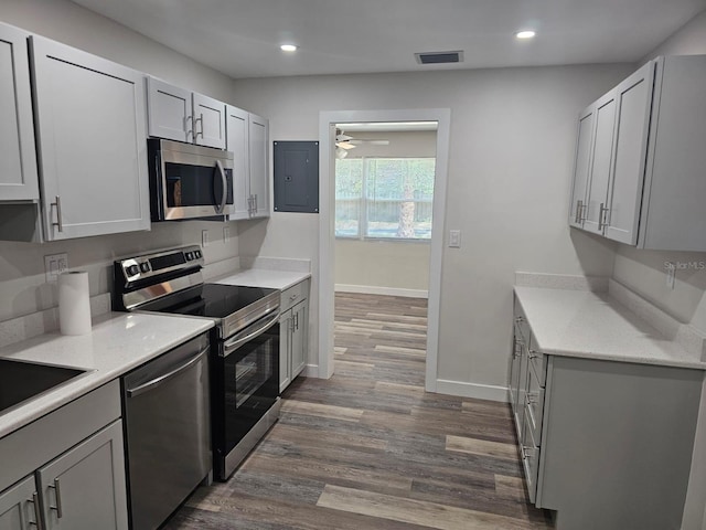 kitchen with visible vents, electric panel, dark wood-style floors, stainless steel appliances, and baseboards