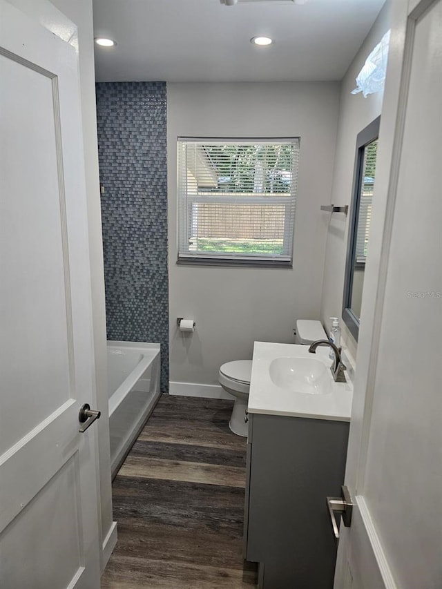 full bathroom with baseboards, toilet, recessed lighting, wood finished floors, and vanity