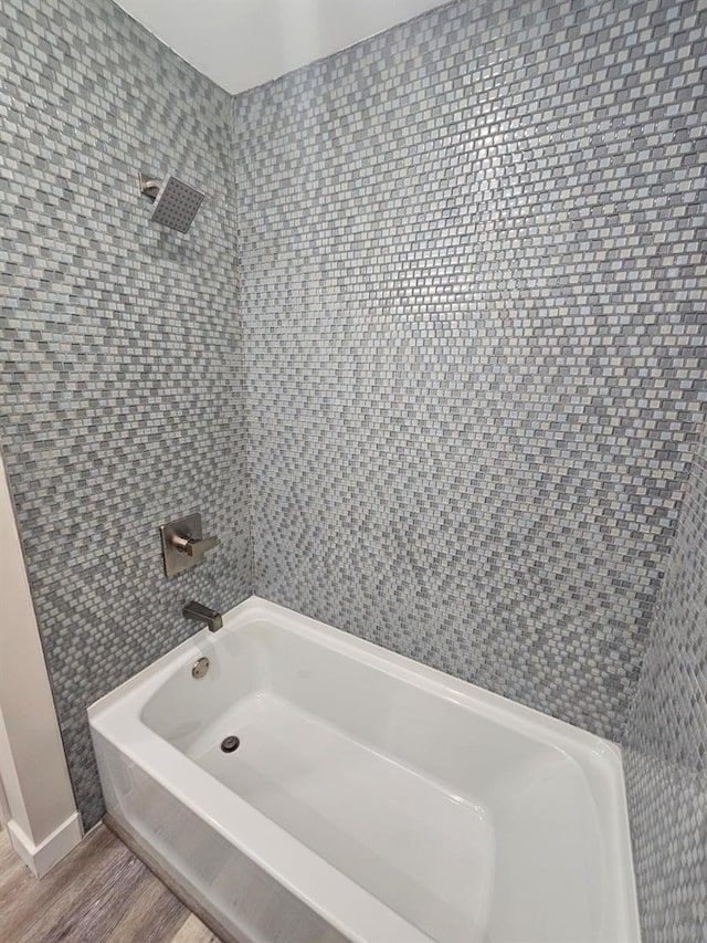 full bath featuring washtub / shower combination and wood finished floors