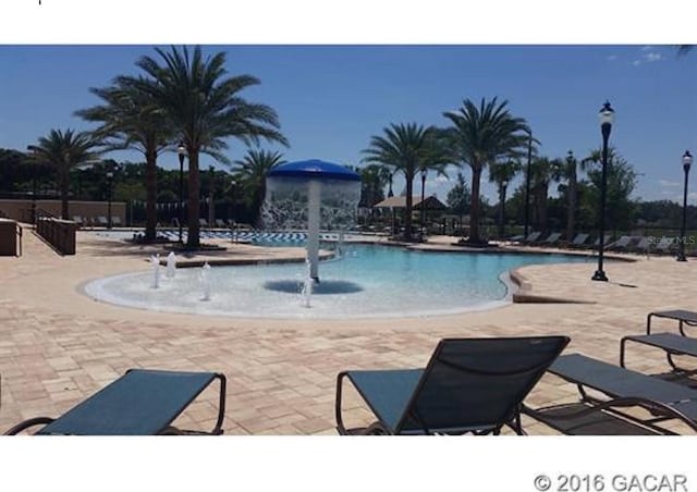 view of pool with a patio and pool water feature