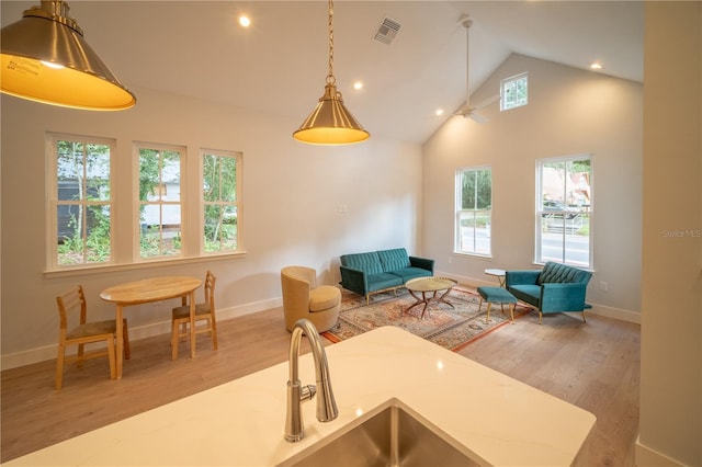 kitchen with hardwood / wood-style floors, pendant lighting, and high vaulted ceiling