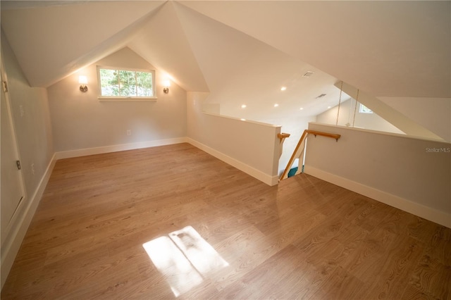 bonus room with hardwood / wood-style floors and vaulted ceiling