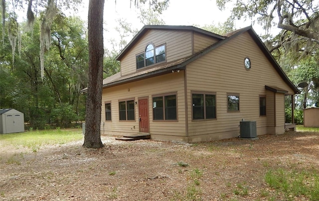 rear view of house with a storage unit and central AC