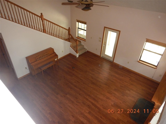 unfurnished living room with dark hardwood / wood-style floors, high vaulted ceiling, ceiling fan, and a healthy amount of sunlight