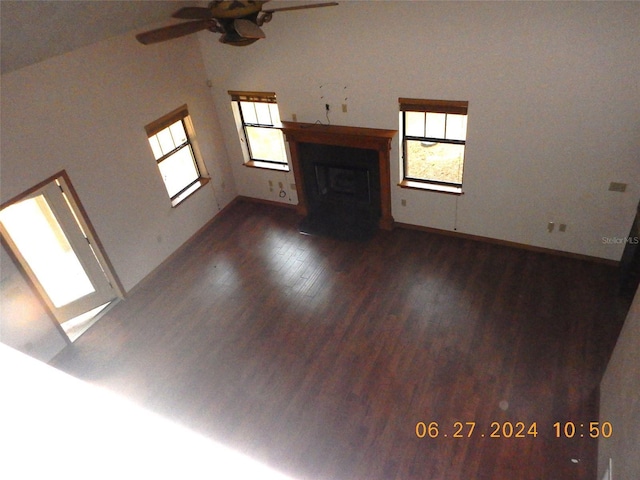 unfurnished living room with ceiling fan, dark hardwood / wood-style flooring, and lofted ceiling