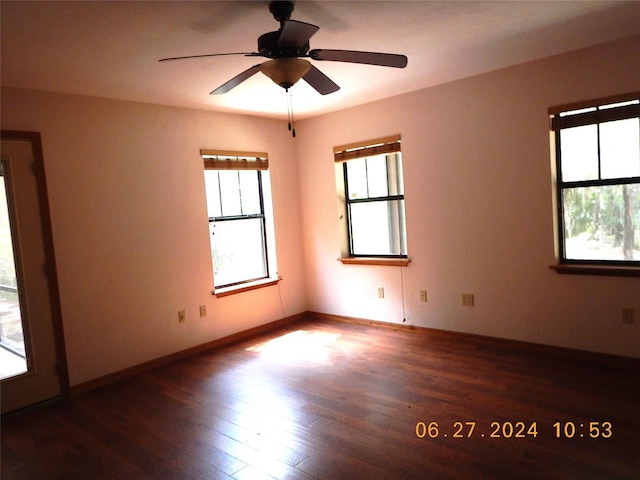 empty room with ceiling fan and dark wood-type flooring