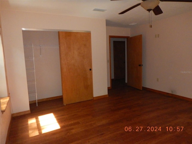 unfurnished bedroom with ceiling fan, a closet, and dark wood-type flooring