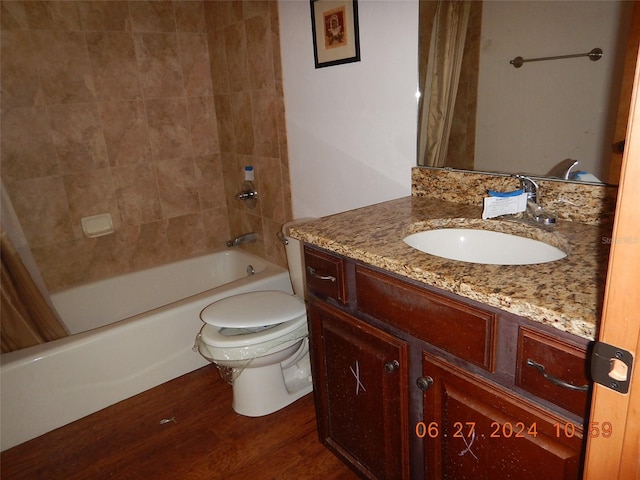 full bathroom featuring hardwood / wood-style flooring, vanity, toilet, and shower / tub combo with curtain