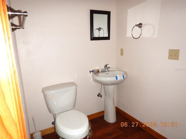 bathroom with hardwood / wood-style floors and toilet