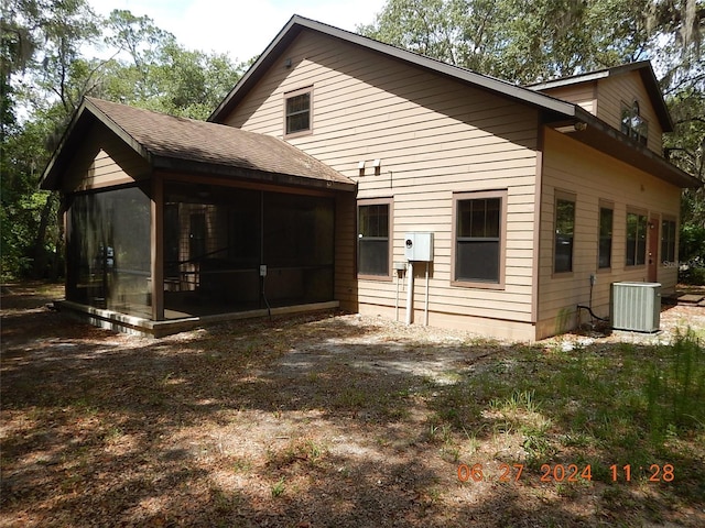 rear view of house featuring a sunroom and central AC