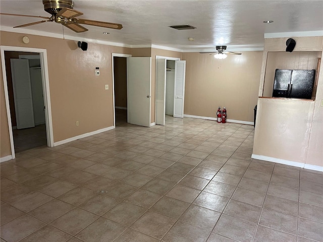 tiled empty room featuring crown molding and ceiling fan