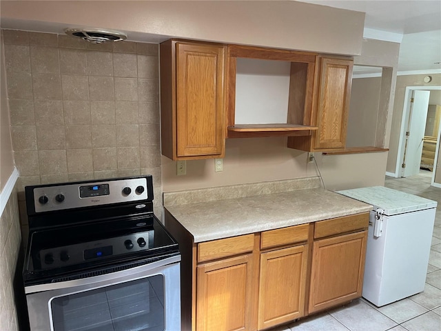 kitchen with light tile patterned flooring, tile walls, stainless steel electric range, and crown molding