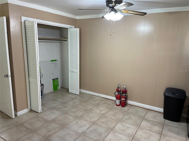 unfurnished bedroom featuring a closet, crown molding, ceiling fan, and light tile patterned floors