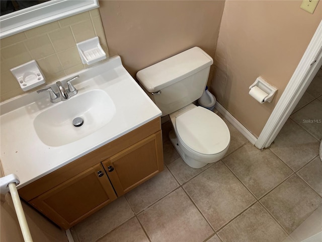 bathroom with vanity, toilet, tile patterned floors, and tasteful backsplash