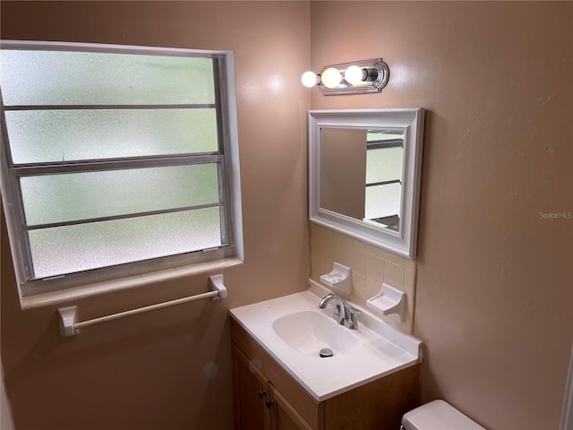 bathroom featuring vanity, tasteful backsplash, and plenty of natural light