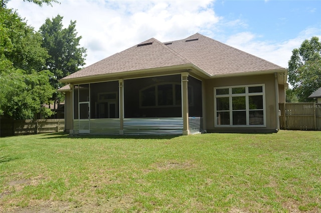 back of property featuring a sunroom and a yard