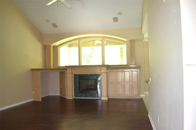 unfurnished living room featuring lofted ceiling, ceiling fan, a high end fireplace, and dark wood-type flooring