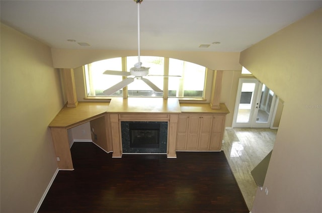 kitchen featuring a premium fireplace, dark wood-type flooring, ceiling fan, and light brown cabinets