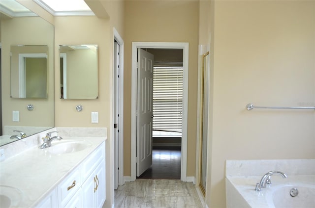 bathroom with dual bowl vanity, hardwood / wood-style floors, and a tub