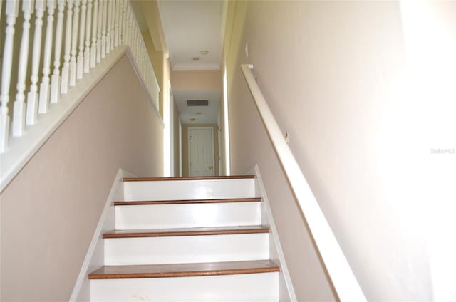 staircase featuring ornamental molding