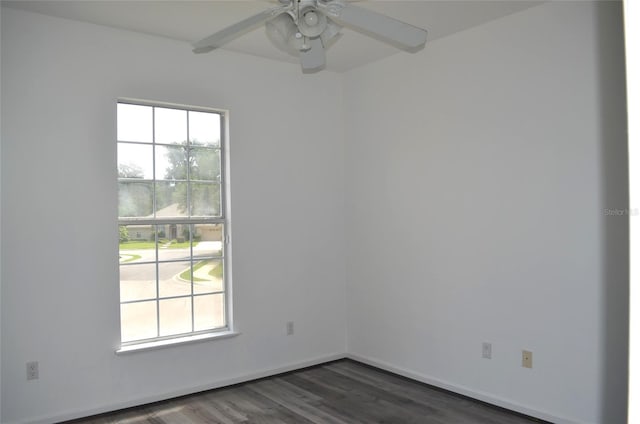 spare room featuring dark hardwood / wood-style flooring, a wealth of natural light, and ceiling fan