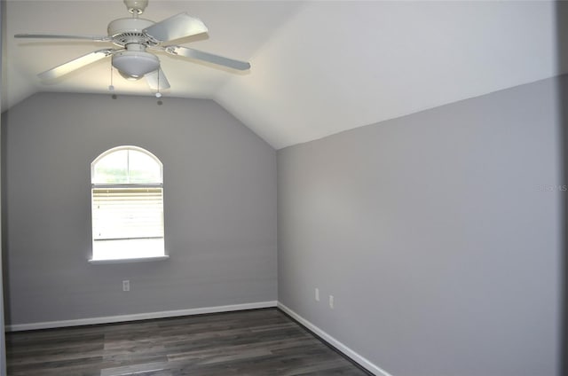 empty room with dark hardwood / wood-style floors, ceiling fan, and vaulted ceiling