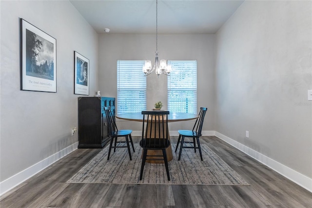 dining room with dark wood-type flooring and a chandelier