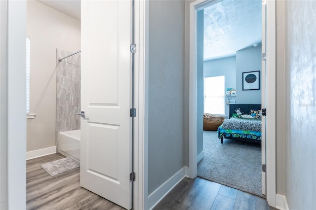 corridor featuring wood-type flooring and a textured ceiling