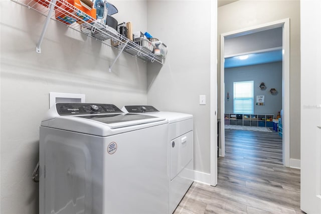 washroom with light hardwood / wood-style floors and washing machine and clothes dryer