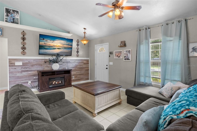 tiled living room featuring ceiling fan, vaulted ceiling, and a tile fireplace