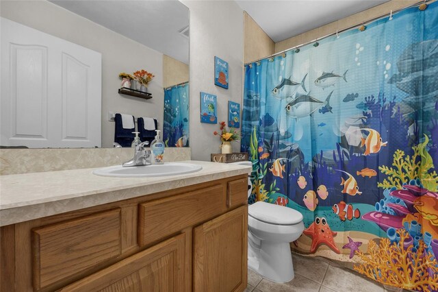 bathroom featuring vanity, tile patterned floors, and toilet