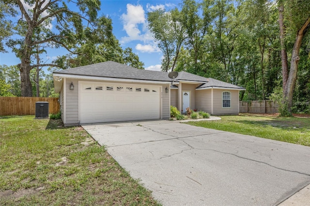 ranch-style house featuring central AC unit, a garage, and a front lawn