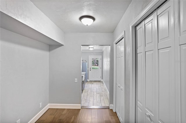 hall with a textured ceiling, crown molding, and dark hardwood / wood-style flooring