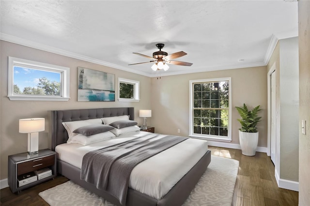 bedroom with dark wood-type flooring, ceiling fan, and ornamental molding