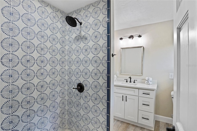 bathroom with wood-type flooring, vanity, and walk in shower