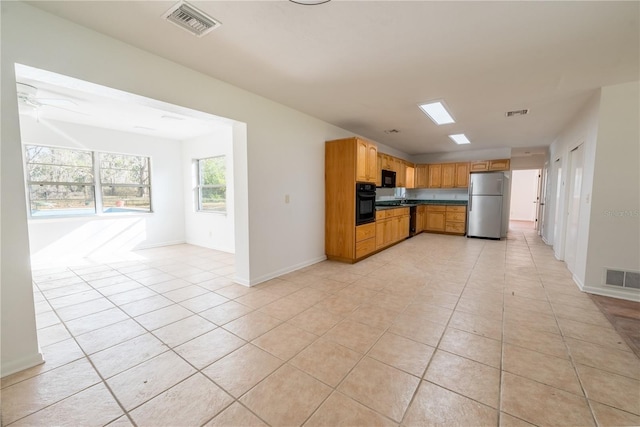 kitchen featuring light tile patterned flooring, ceiling fan, and black appliances